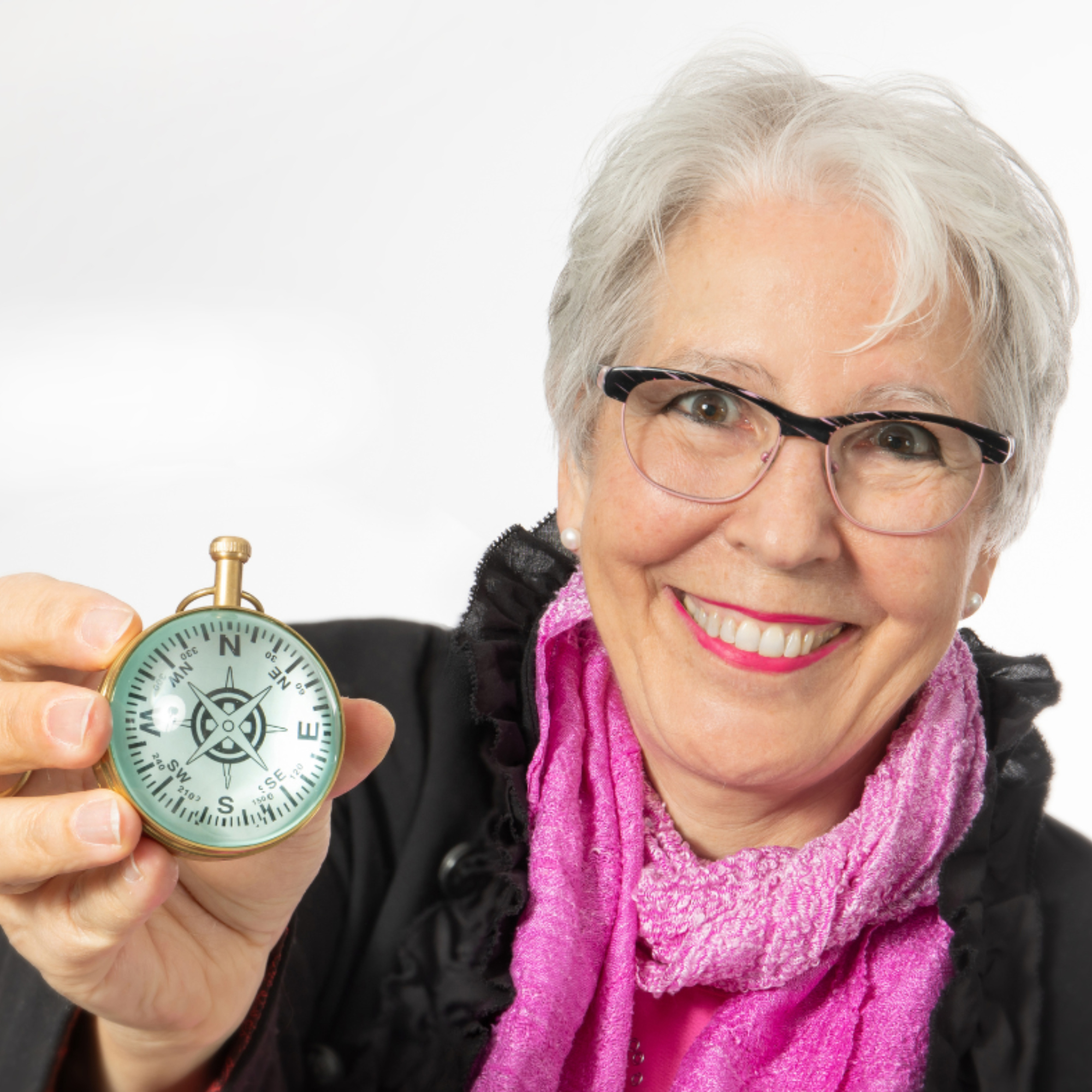 Elisabeth Tanner hält lächelnd einen goldenen Kompass in der Hand